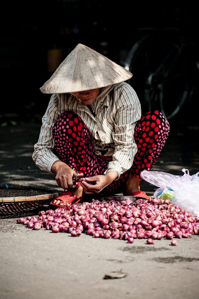 Вьетнамская женщина чистит лук